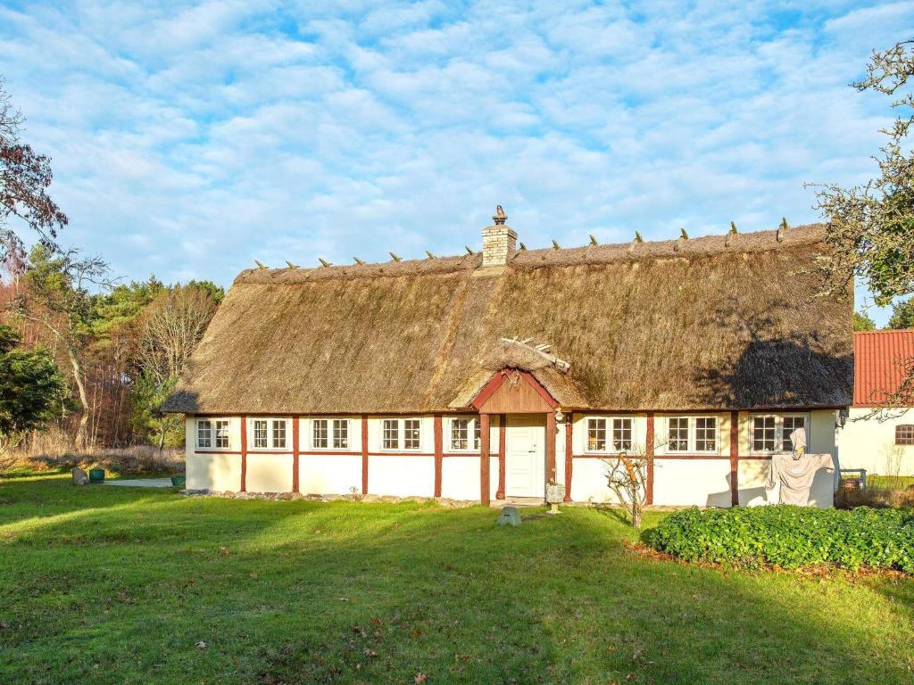 une maison ancienne avec un toit de chaume sur un champ dans l'établissement Holiday home Læsø LIII, à Læsø