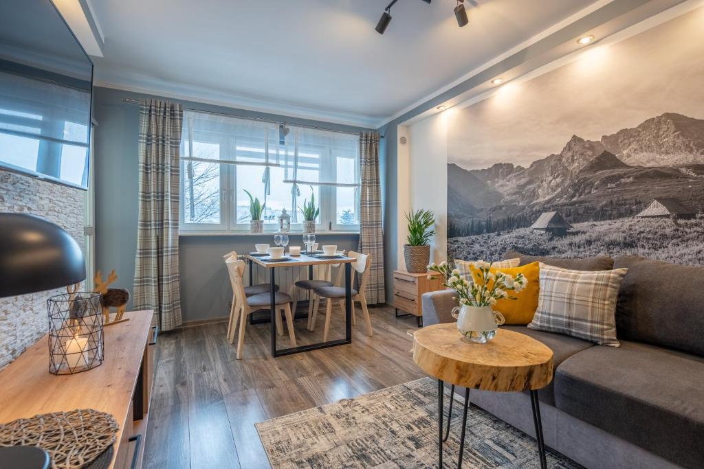 a living room with a couch and a table at Apartament Dworzec Tatrzański in Zakopane