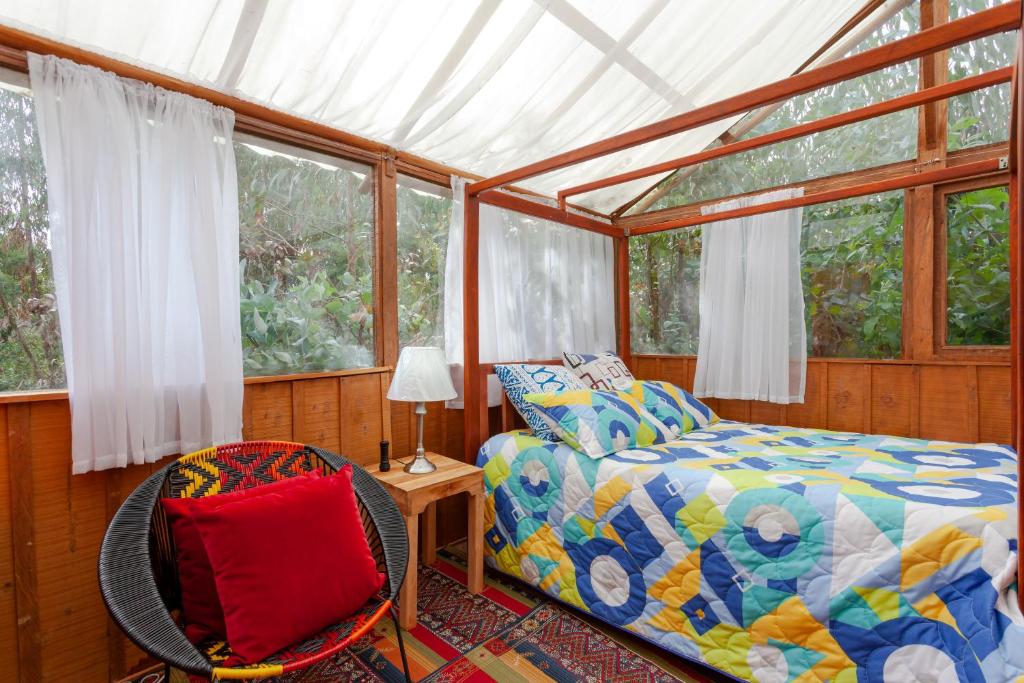 1 dormitorio con 1 cama y 1 silla en NUEVO ! Cabañas en medio de la naturaleza cerca Club Nautico en Guatavita
