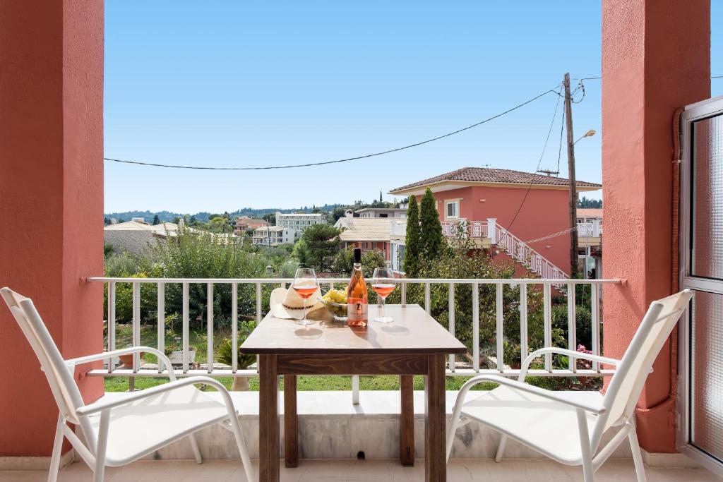 a table and two chairs on a balcony with a view at Marietta's Resort by Konnect, Gouvia Corfu in Gouvia