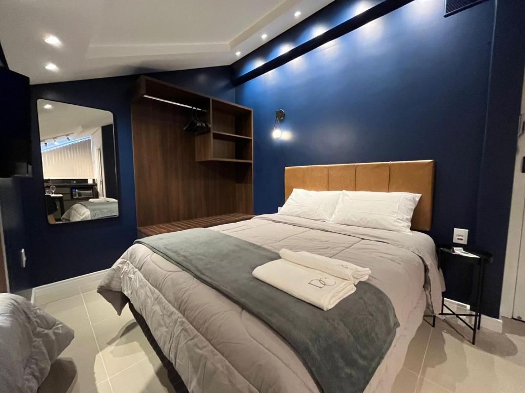 una camera con un grande letto con una parete blu di Loft Dona Clara 204 no coração de Pomerode a Pomerode