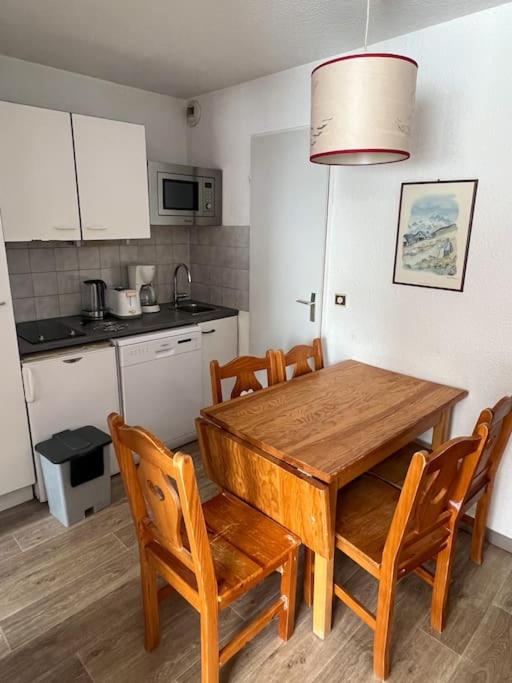 - une cuisine avec une table à manger en bois et des chaises dans l'établissement Altineige Center village, à Val Thorens