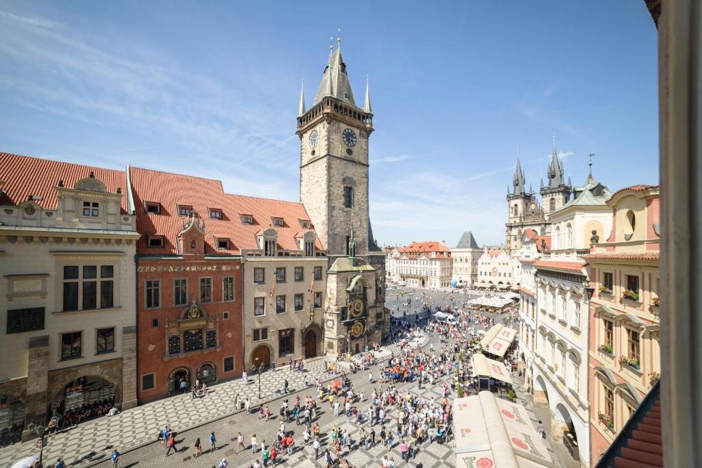una multitud de personas en una ciudad con una torre de reloj en Apartments Old Town Square 27, en Praga