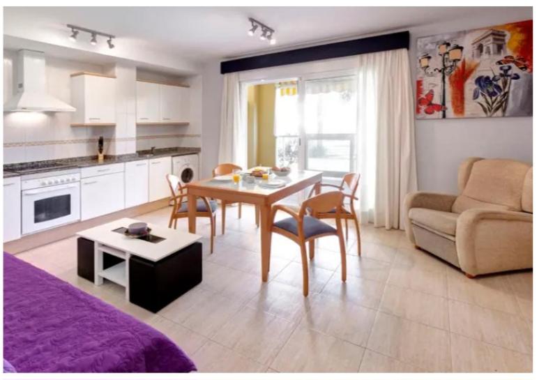 een keuken en een woonkamer met een tafel en een bank bij La Riviera in Denia