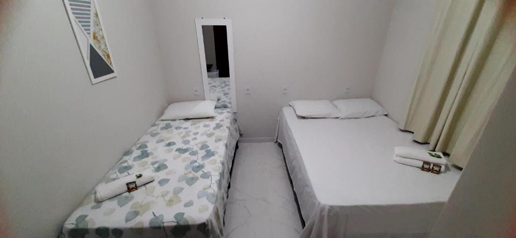 two twin beds in a small room with a window at Pousada Brilho dos Lençóis in Barreirinhas