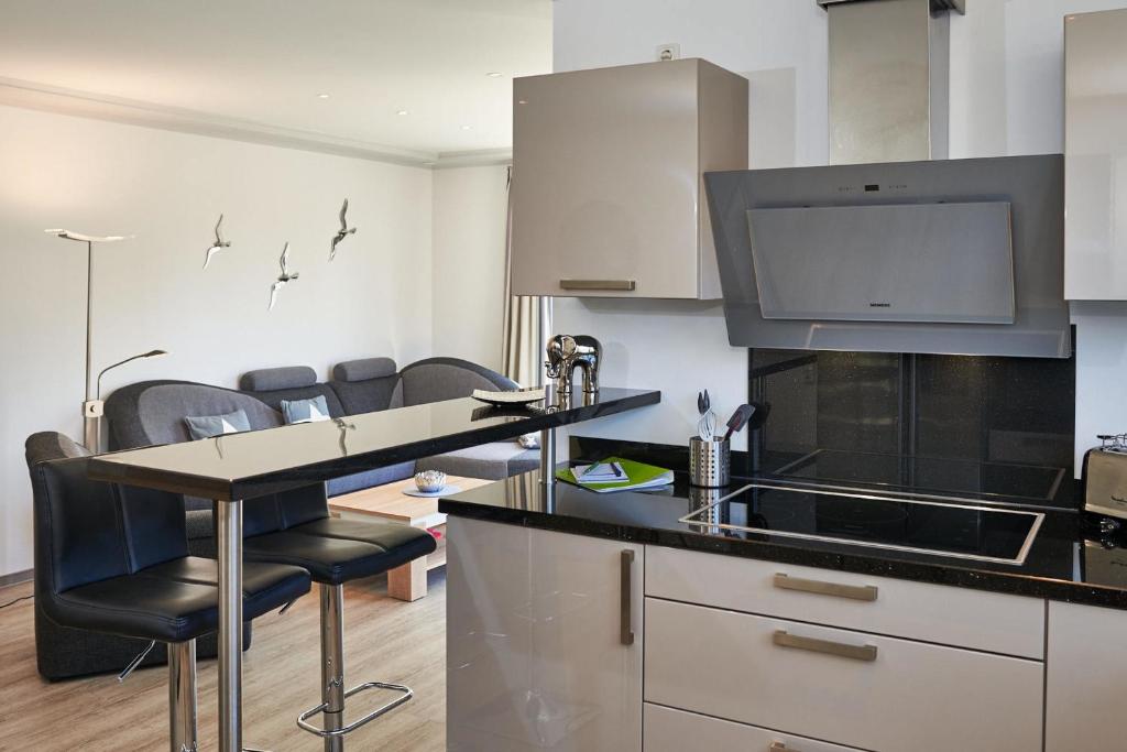 une cuisine avec un comptoir et un bar avec des chaises dans l'établissement STRANDPERLE - 73513, à Eckernförde