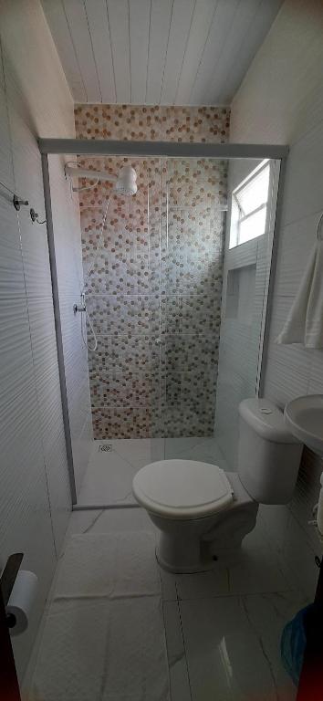 a white bathroom with a toilet and a shower at Pousada Brilho dos Lençóis in Barreirinhas
