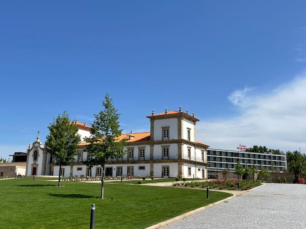 アルコス・デ・ヴァルデヴェスにあるSolar do Requeijo by Luna Hotels & Resortsの前方に芝生の広い白い建物