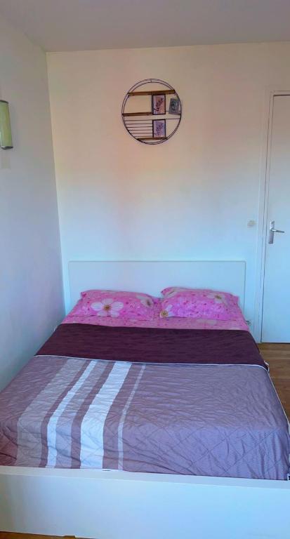 a bedroom with a bed with a purple bedspread and a mirror at Chambre Propre Calme dans un Quartier Pavillonnaire Proche de Paris, La Défense, Les champs Élysées et Toutes Commodités in Nanterre