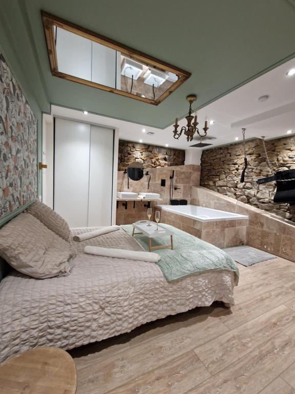 a bedroom with a large bed and a bath tub at L'éxperience LOVE ROOM in LʼÉtrat