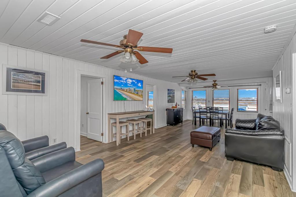 a living room with furniture and a ceiling fan at Pet Friendly Beach House! Private Dock On Channel! Private Pool! 5 bedroom - 3 bath! in Myrtle Beach