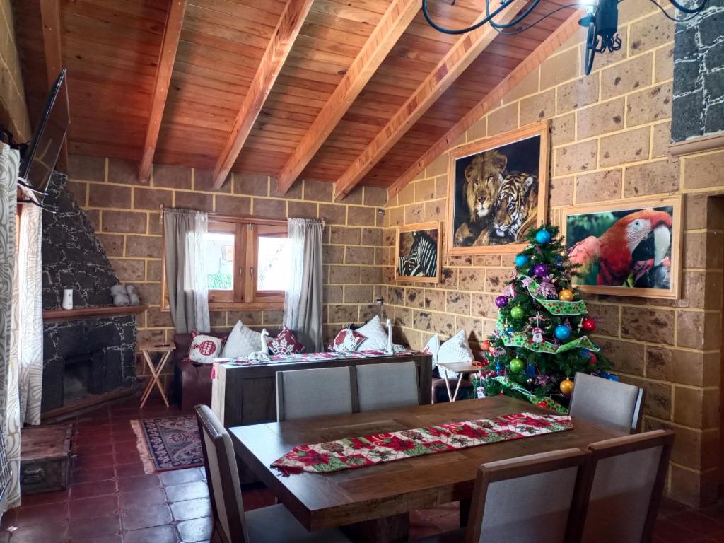 un comedor con un árbol de Navidad y una mesa en Cabaña el piñon en Ezequiel Montes, en Ezequiel Montes
