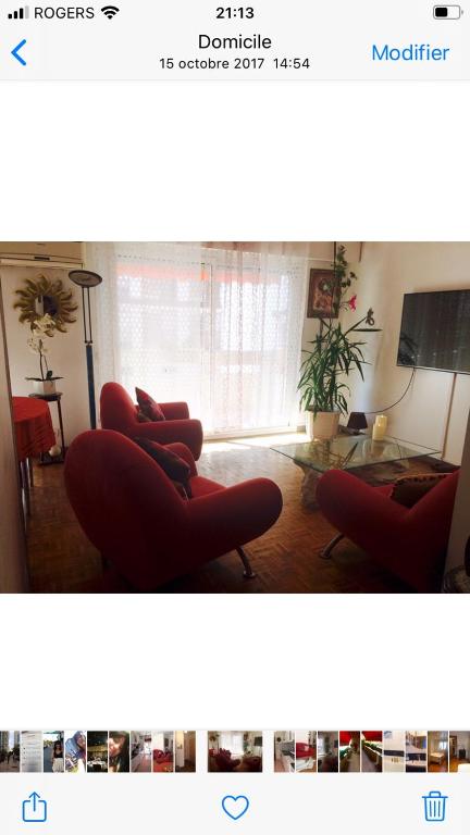 ein Wohnzimmer mit 2 roten Stühlen und einem Tisch in der Unterkunft Bel appartement très bien situé avec place de parking in Marseille