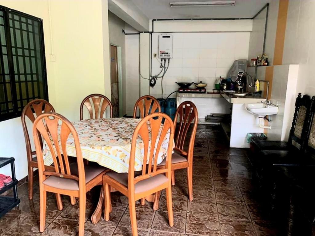 a dining room table and chairs in a kitchen at Sakura Guest House in Cameron Highlands