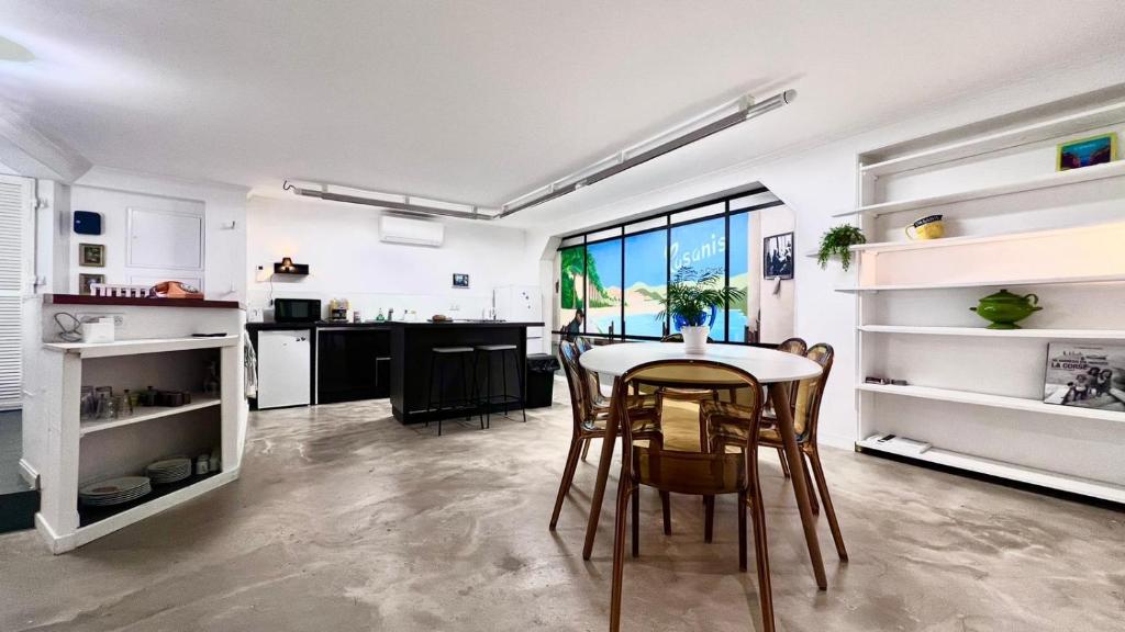 a kitchen and dining room with a table and chairs at Coliving Napoléon III in Ajaccio