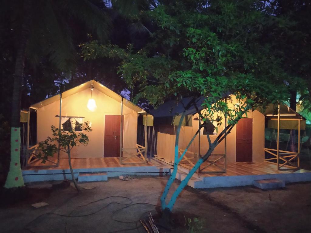 a small house with a tree in front of it at shree farm in Alibaug