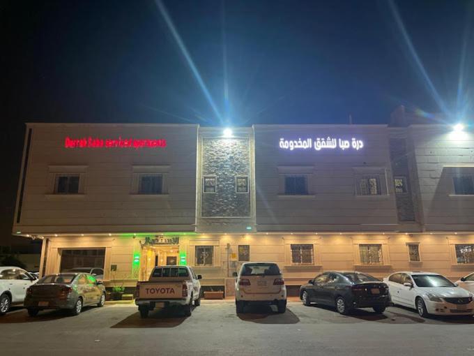 un bâtiment avec des voitures garées devant lui la nuit dans l'établissement برج الياسمين 2, à Riyad