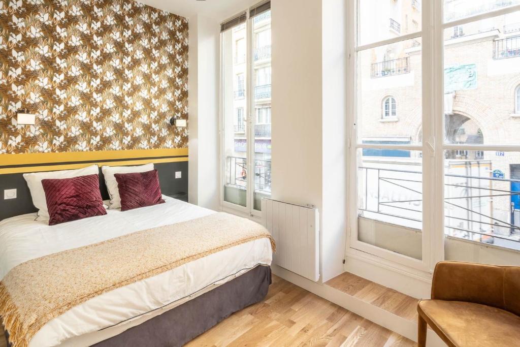 ein Schlafzimmer mit einem Bett und einem großen Fenster in der Unterkunft Cosy flat in the heart of Belleville in Paris