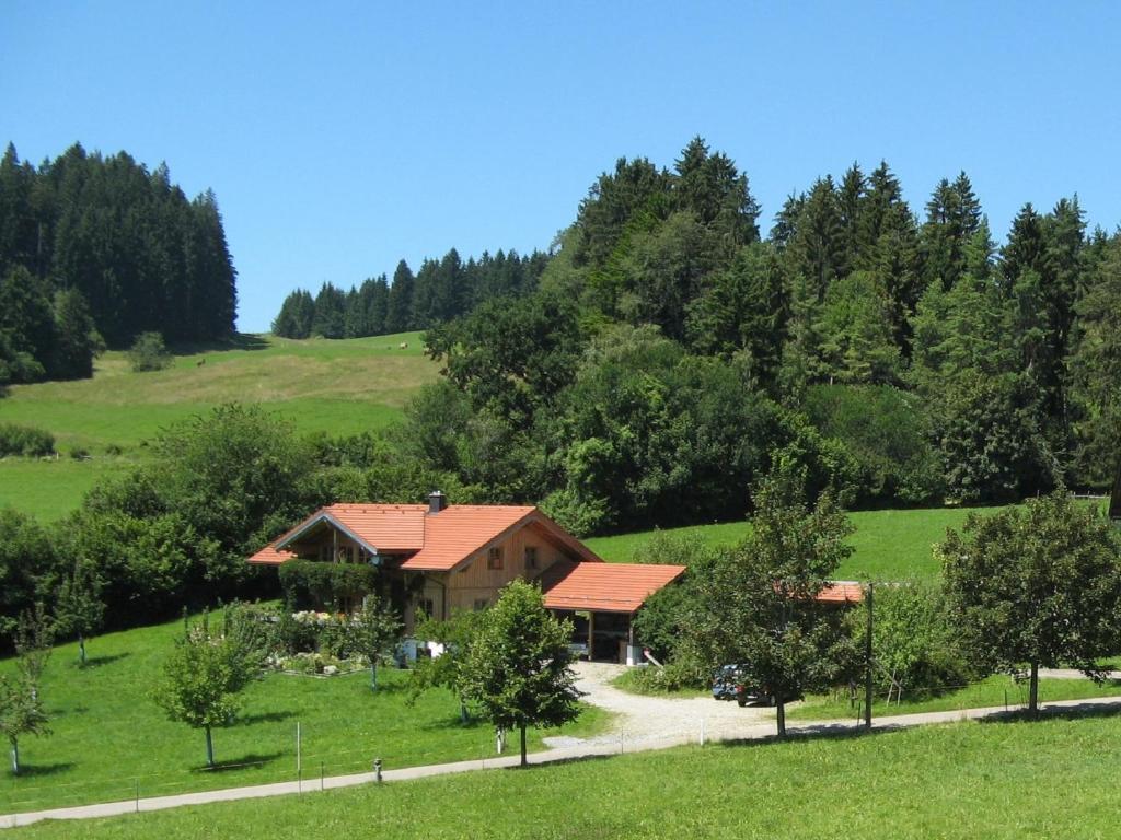 ein Haus mitten auf einem grünen Feld in der Unterkunft Urlaubshof Bechteler in Waltenhofen