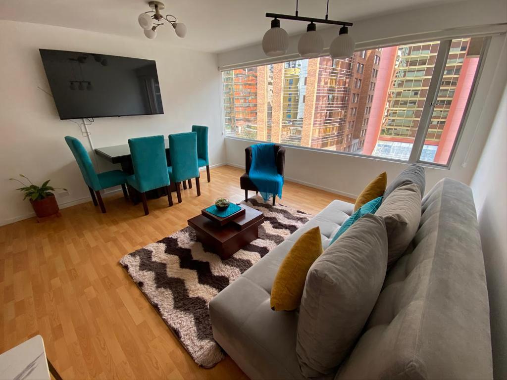 uma sala de estar com um sofá e uma mesa em Rep del Salvador, Quito 1-bedroom condo with parking and Netflix em Quito