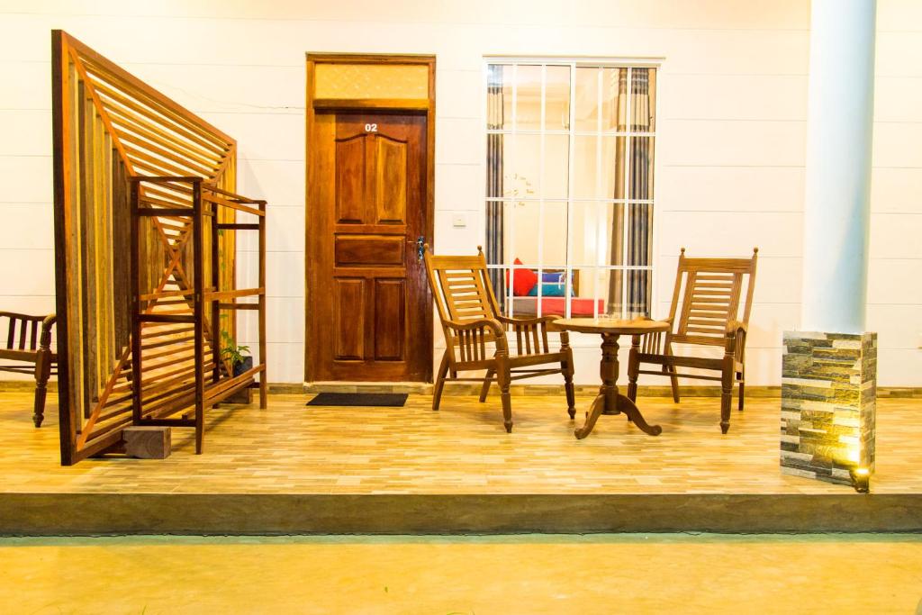 eine Veranda mit einem Tisch, Stühlen und einer Tür in der Unterkunft Inn Sea Horizon Ahungalla in Ahungalla