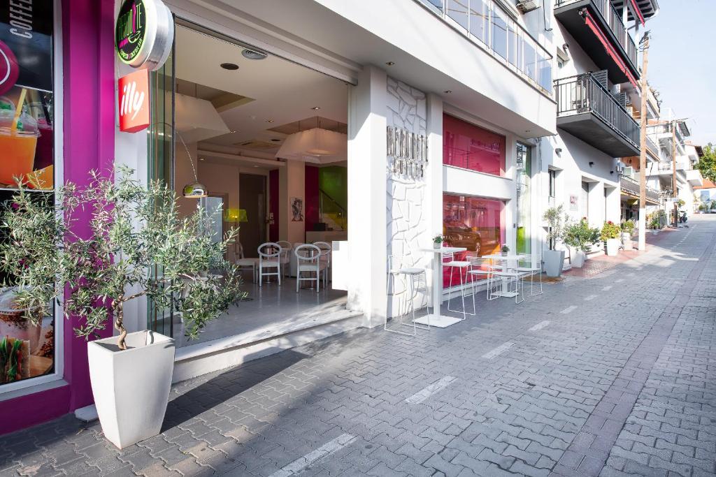 une rue avec des tables et des chaises à l'extérieur d'un magasin dans l'établissement Afrodite Suites, à Potos