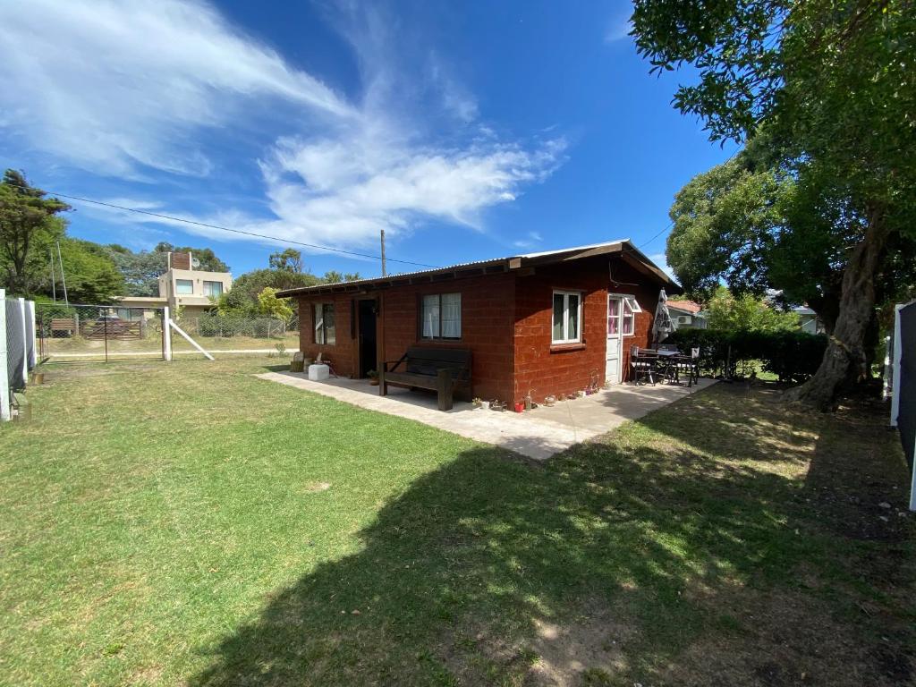 a small red brick house with a grass yard at Evergreen in Mar del Plata