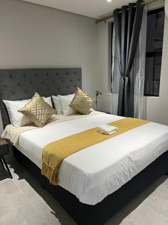 a bedroom with a large bed with white sheets and pillows at TheRestInn @ 2Six2 Florida in Durban