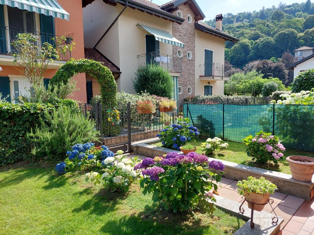 einen Garten vor einem Haus mit Blumen in der Unterkunft Casa Ilda in Orta San Giulio