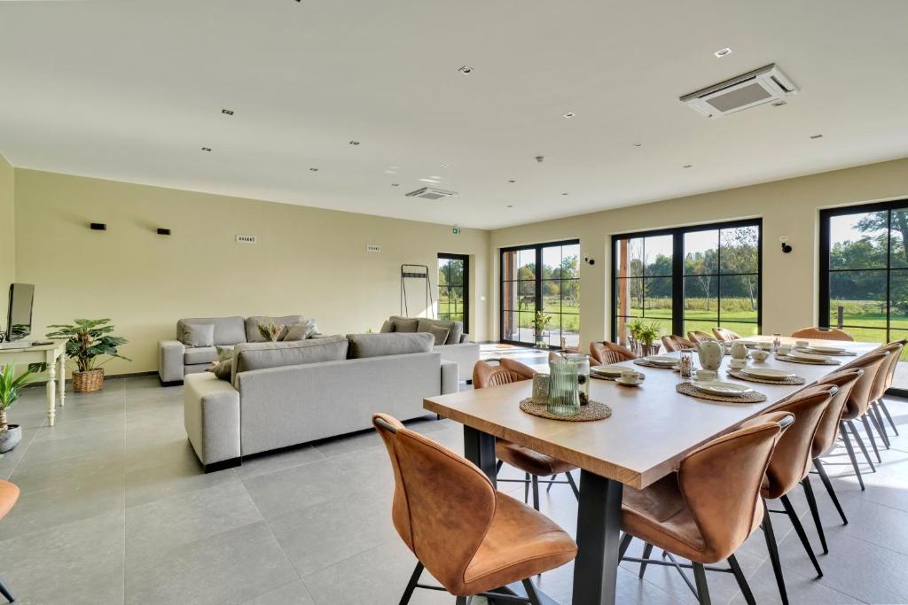 a dining room with a table and chairs and a couch at Franciscushof in Pelt