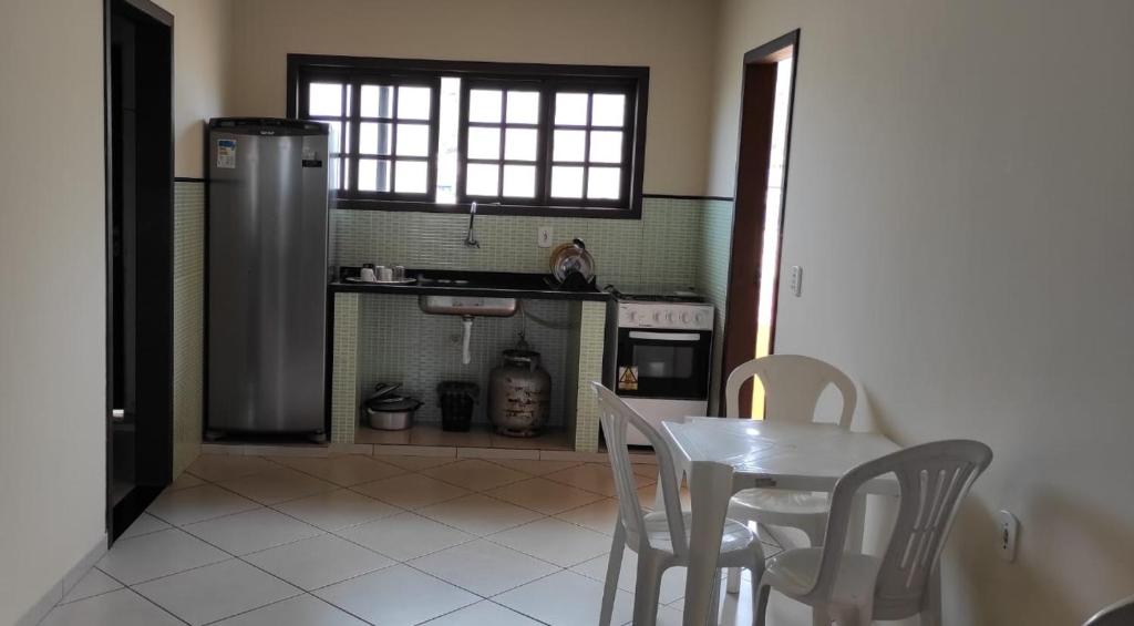 una pequeña cocina con mesa y nevera en Apto em Arraial, en Arraial do Cabo