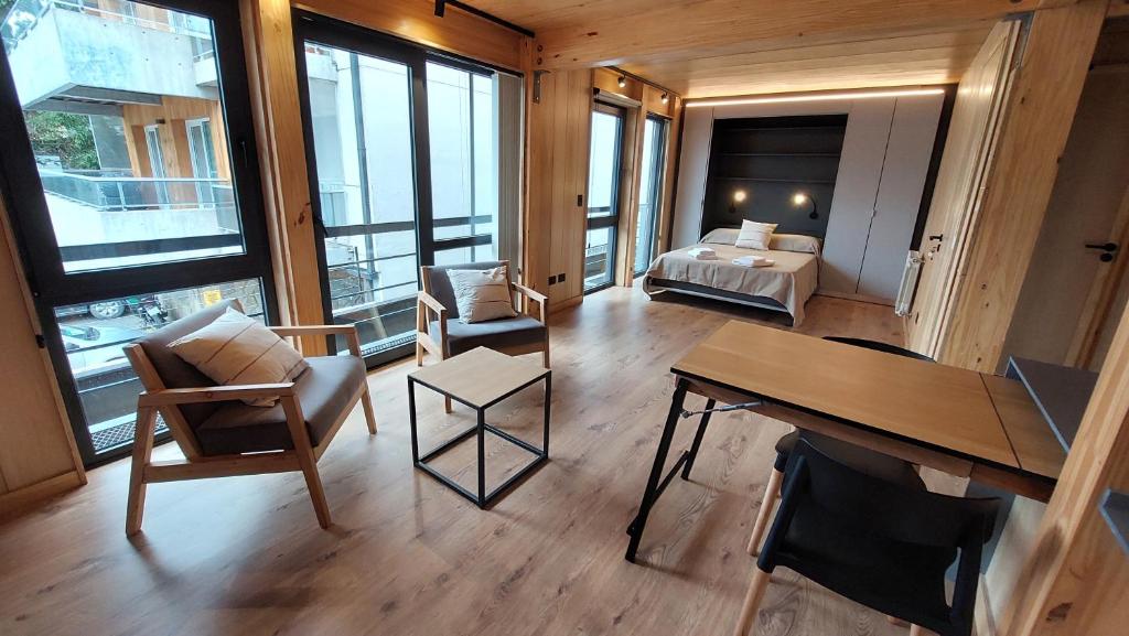 Großes Zimmer mit einem Bett, einem Schreibtisch und Stühlen in der Unterkunft Departamento 2 ambientes, cálido y luminoso, con buena vista, en el centro de SMA. 14V5 in San Martín de los Andes