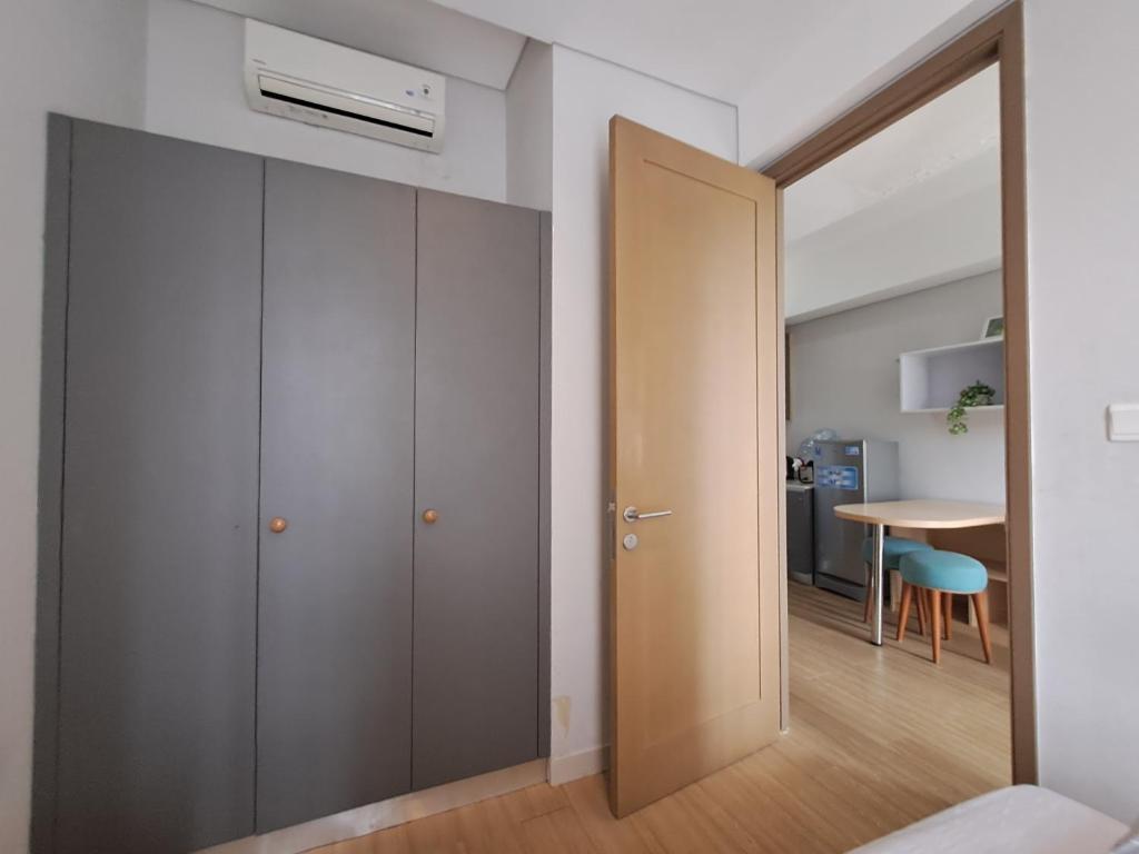 einen Flur mit einer Tür, die zu einem Zimmer mit einem Tisch führt in der Unterkunft 1 BR Apartment Near Shopping Malls in Jakarta