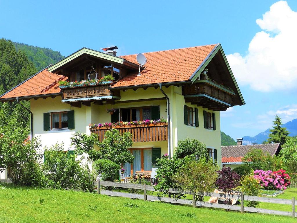 een huis met balkons en bloemen erop bij Ferienwohnung Kaiserblick in Sachrang