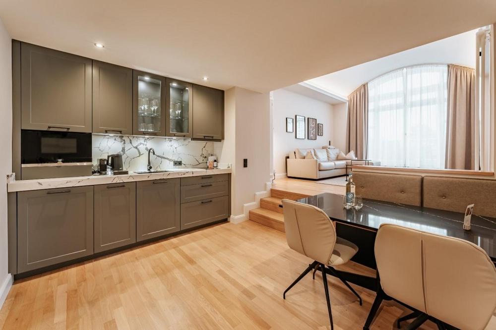 a kitchen with a table and chairs and a living room at Strandhotel Kurhaus Juist in Juist