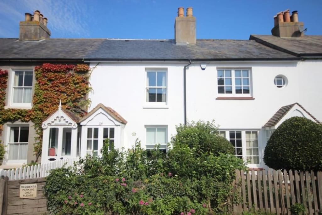 a white house with a fence in front of it at Mary's Cottage in Kingsdown