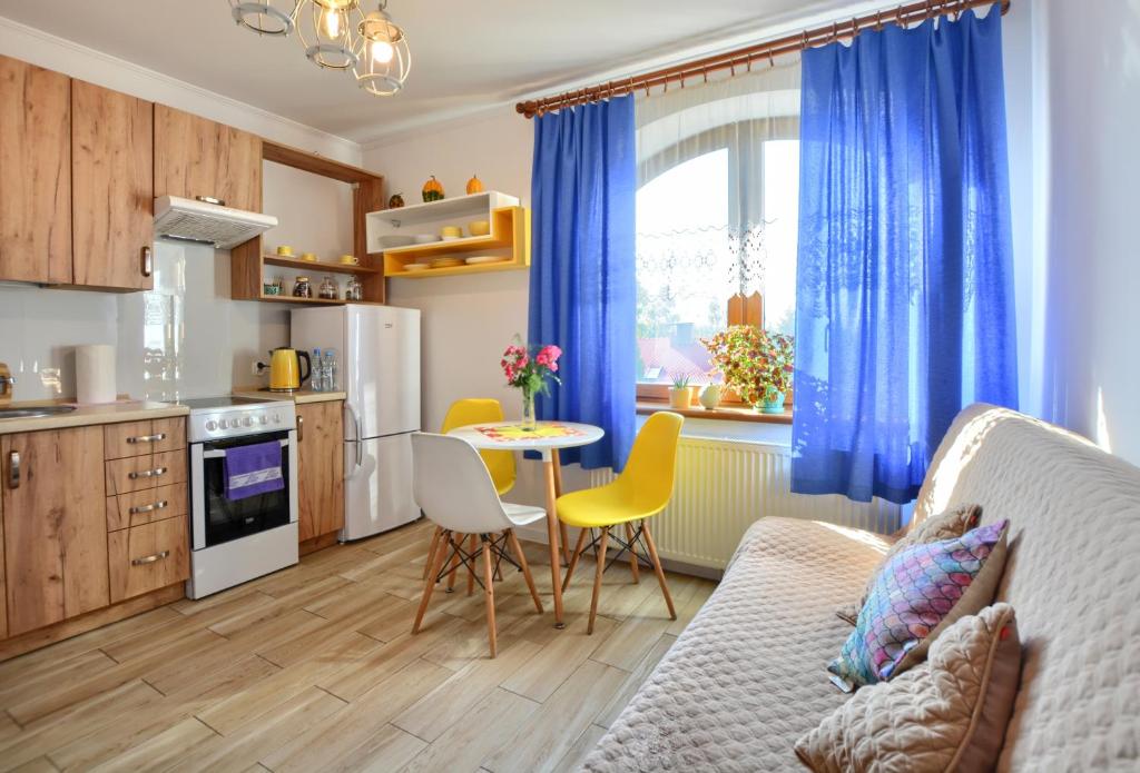 cocina y sala de estar con sofá y mesa en Apartament Gościnny, en Łańcut