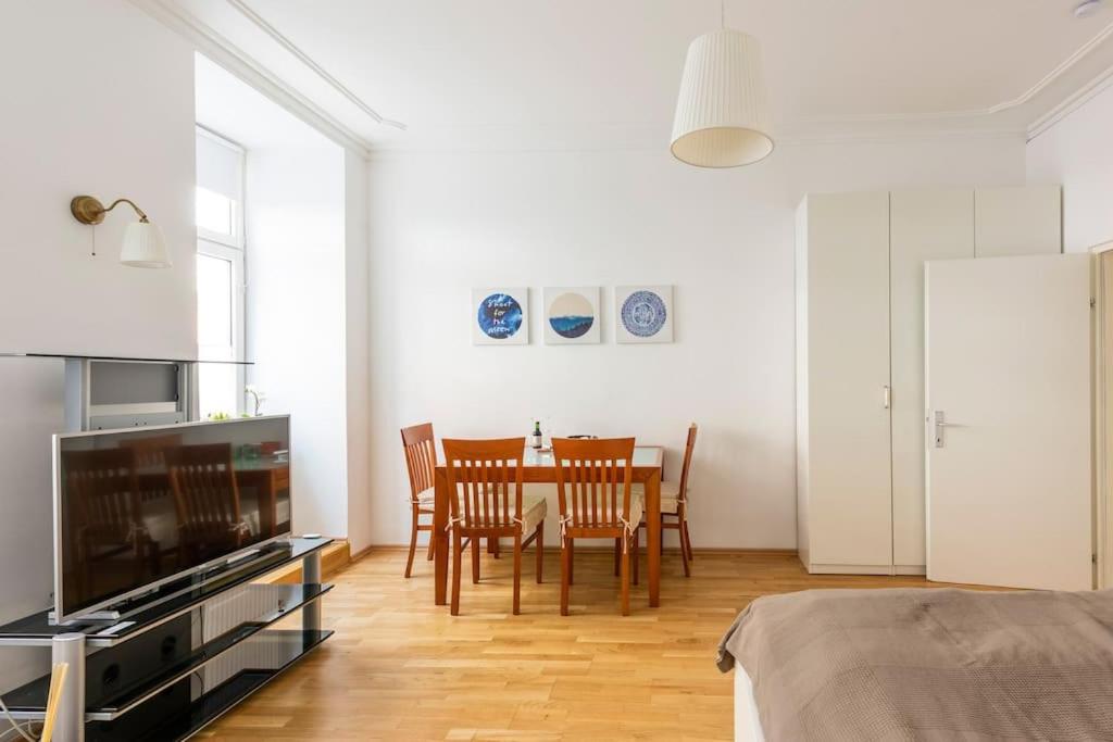 a living room with a table and chairs and a television at Cozy Home Vienna in Vienna
