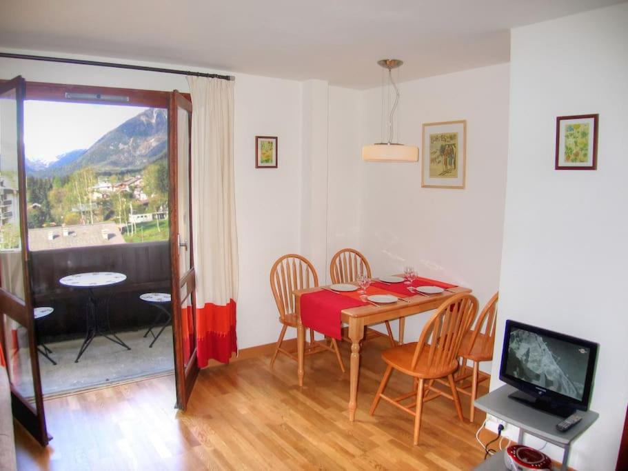 una sala da pranzo con tavolo, sedie e TV di Periades, central Chamonix apt a Chamonix-Mont-Blanc