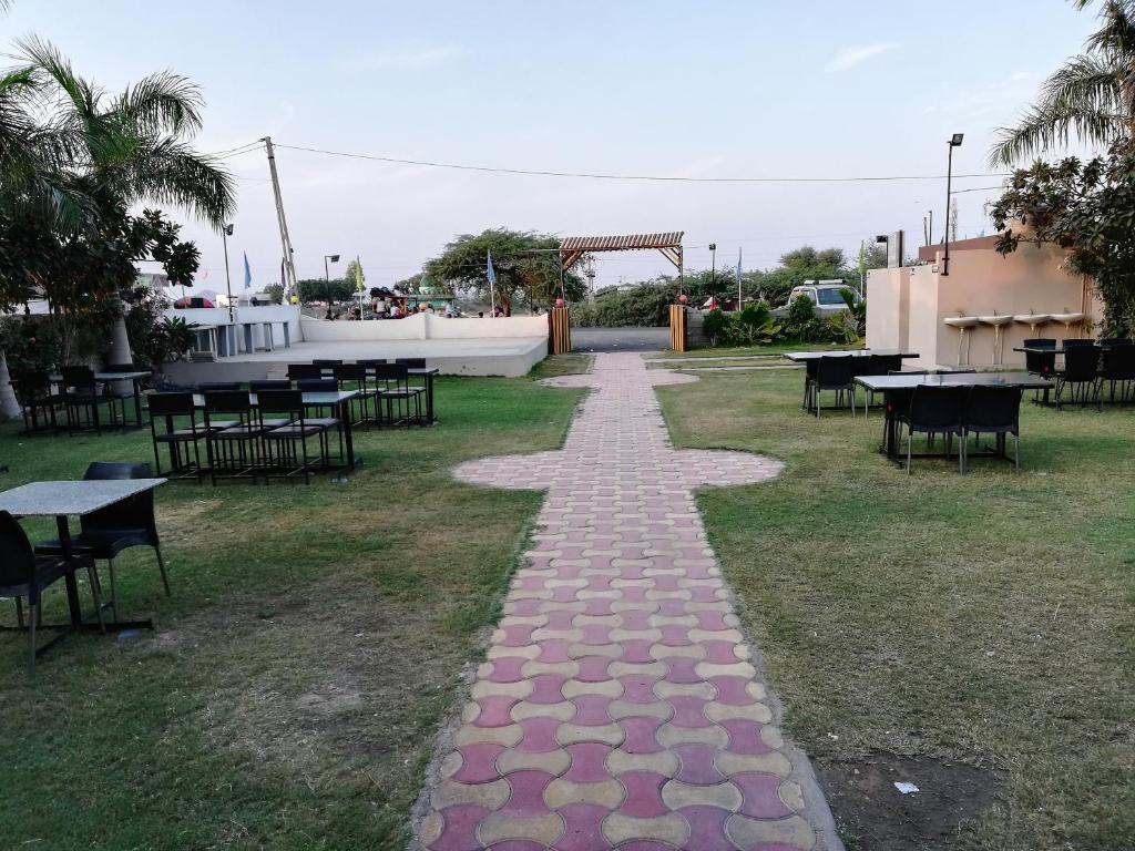 a walkway with tables and tables in a park at Hotel Shiv Regency in Kukma