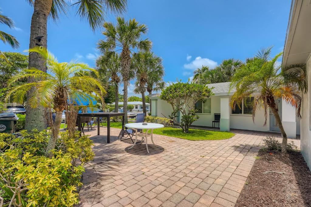 eine Terrasse mit Palmen und einem Tisch in der Unterkunft Singer Island Stunner 2 BR in West Palm Beach