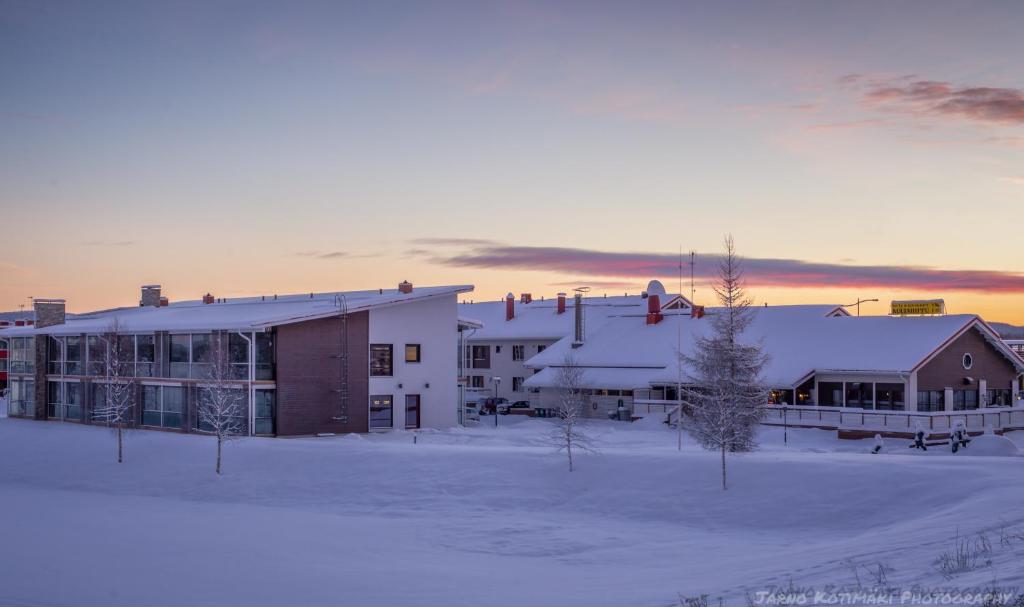 een groep gebouwen in een met sneeuw bedekt veld bij Kultahippu Hotel & Apartments in Ivalo