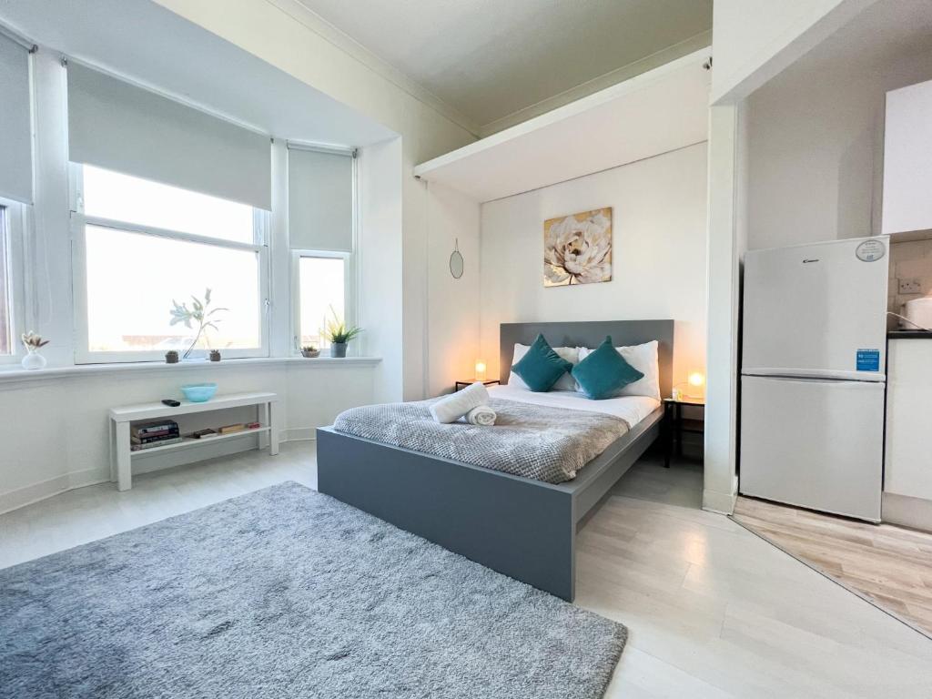 a bedroom with a bed and a refrigerator at 1Bd Glasgow Apartment in Glasgow