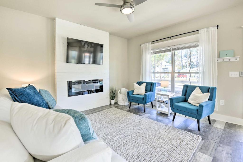 sala de estar con sofá, 2 sillas y chimenea en Modern Santa Rosa Beach Retreat with Yard and Patio!, en Santa Rosa Beach