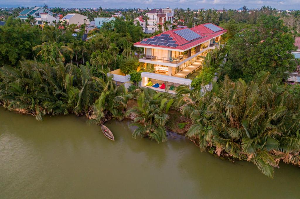 an island with a house with a solar roof on the water at Akala Villa Hoi An in Hoi An