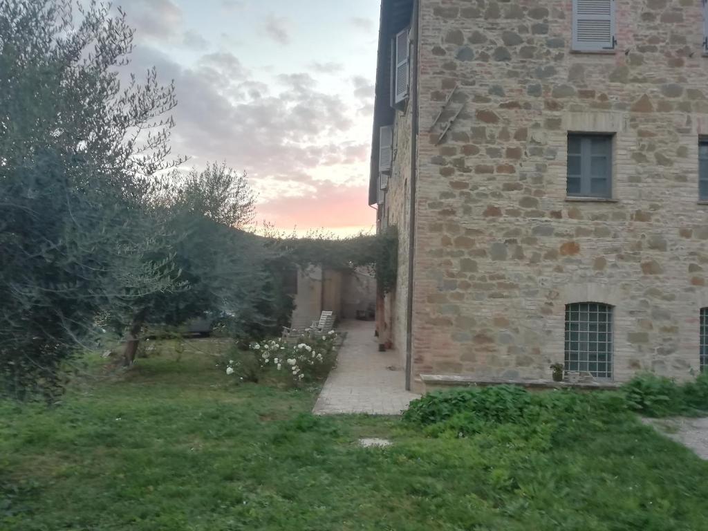 un edificio de ladrillo con una acera junto a un patio en Antico Casale Il Borgo San Martino in Campo, en San Martino in Campo
