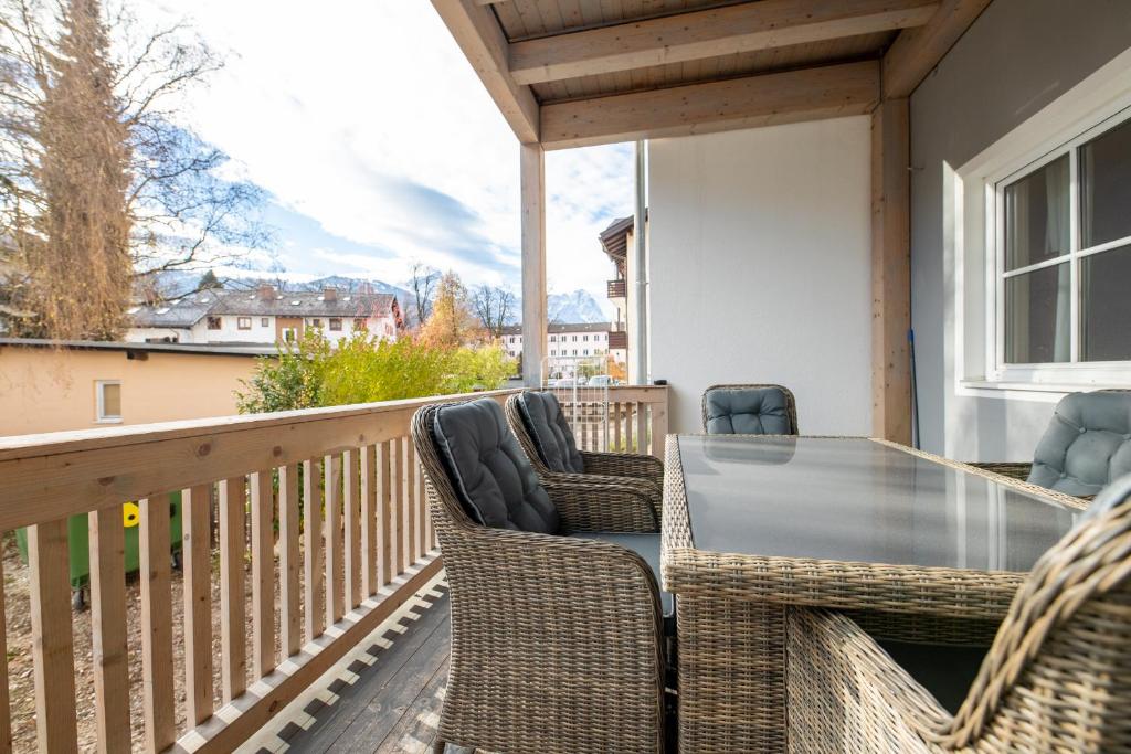 a deck with a table and chairs on a balcony at Haus Ludwig Murmeltier in Garmisch-Partenkirchen