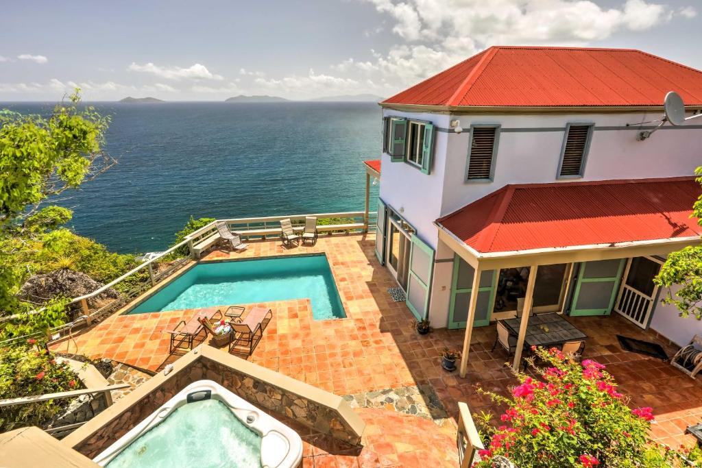 a house with a swimming pool next to the ocean at St Thomas Cliffside Villa with Pool and Hot Tub! in Lovenlund