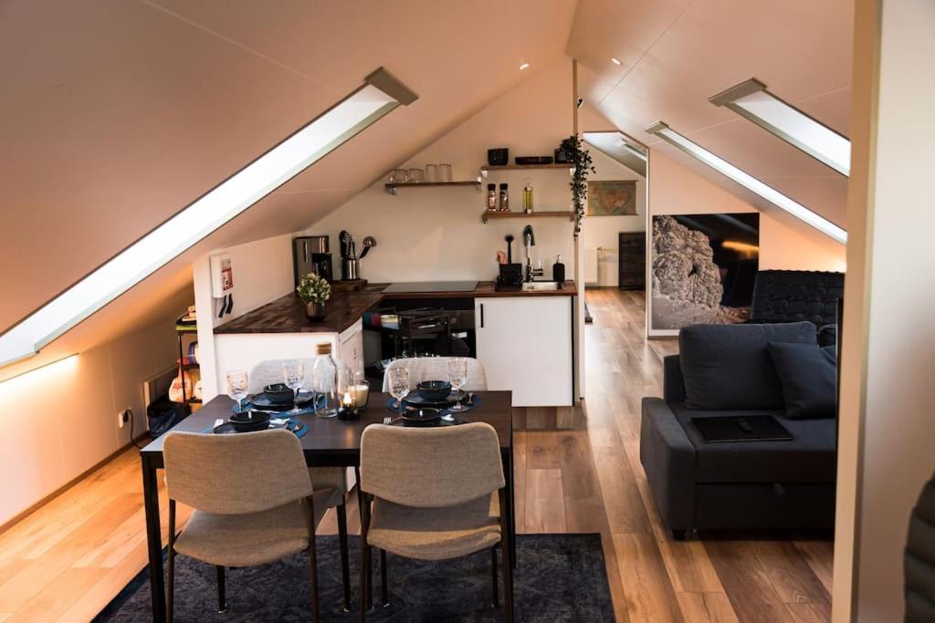 een kamer met een tafel en stoelen en een woonkamer bij Scenic Penthouse - Ocean view & skylight windows in Siglufjörður