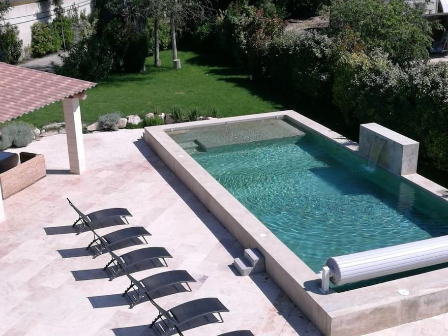 une piscine avec des chaises longues dans une cour arrière dans l'établissement Maison de 6 chambres avec piscine privée, jardin aménagé et wifi à Pernes-les-Fontaines, à Pernes-les-Fontaines